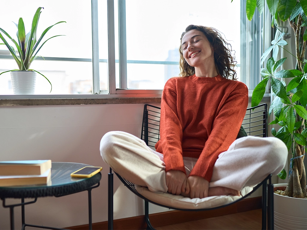 smiling pretty woman relaxing sitting on chair at home